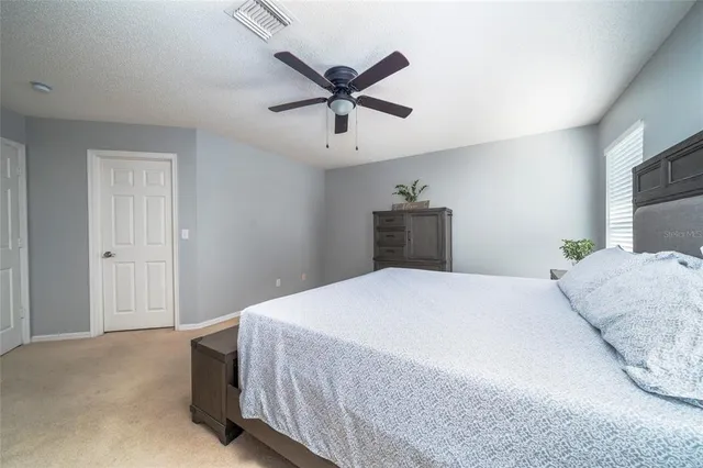 a bedroom with a large bed and a chandelier