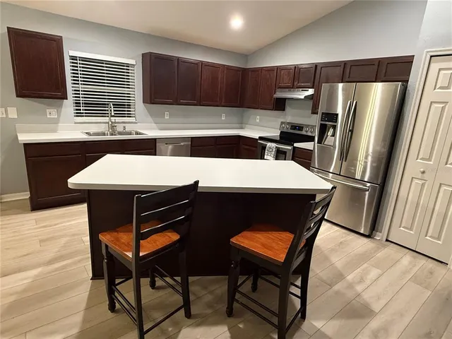 a kitchen with a table chairs refrigerator and microwave