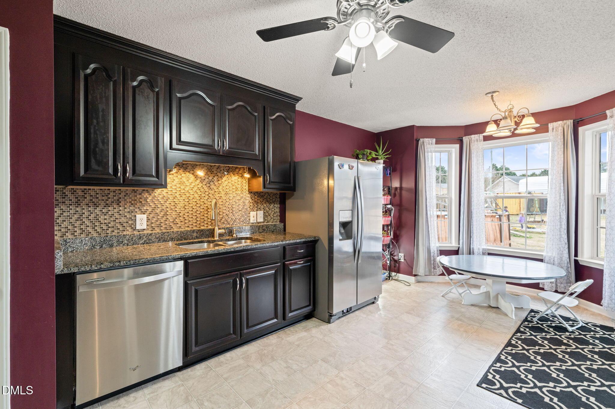 16 Saddle Ridge Drive Willow Spring, NC 27592 - Photo 20 of 57 a kitchen with stainless steel appliances granite countertop a refrigerator a sink dishwasher a stove and a dining table with wooden floor