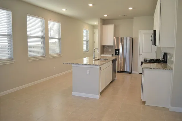 a kitchen with refrigerator cabinets and a sink