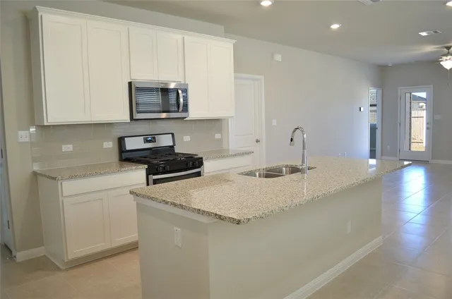 a kitchen with a sink and white cabinets