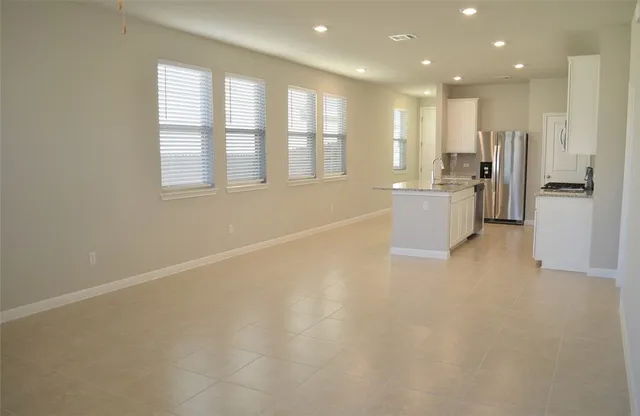 a view of an empty room with a kitchen