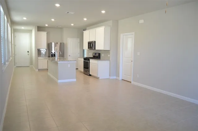 a view of large kitchen with cabinets and stainless steel appliances