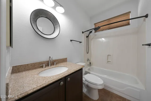 a bathroom with a granite countertop sink toilet and a mirror
