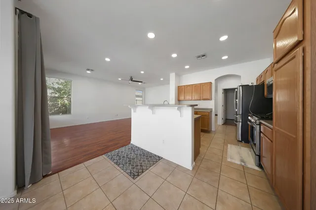 a kitchen with stainless steel appliances kitchen island granite countertop a refrigerator and a sink