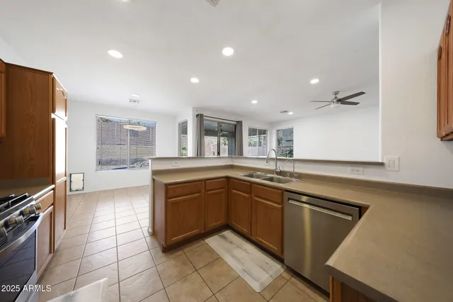 a large kitchen with stainless steel appliances a large counter top a stove and a refrigerator