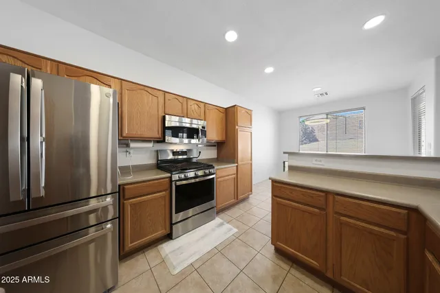 a kitchen with stainless steel appliances granite countertop a refrigerator and a stove top oven
