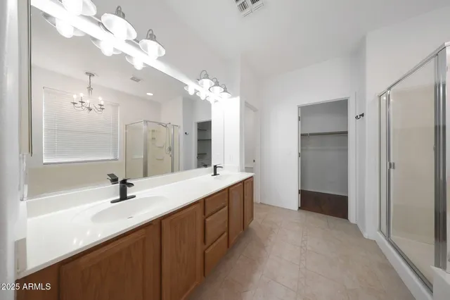 a bathroom with a double vanity sink mirror and shower