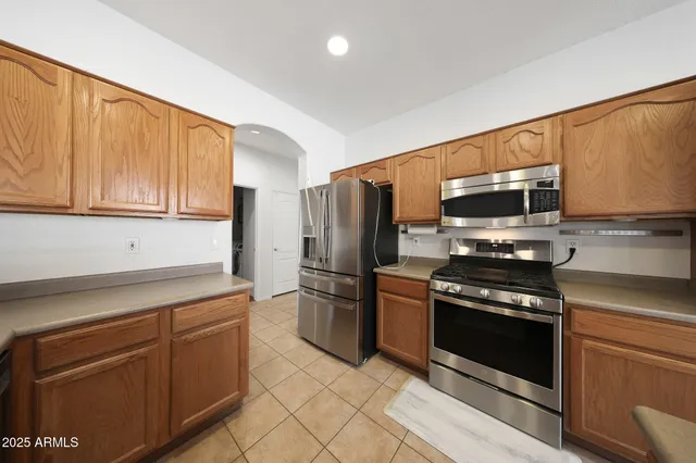 a kitchen with granite countertop a refrigerator stove and microwave
