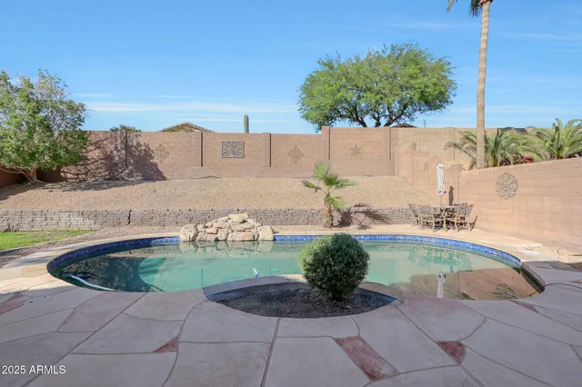a swimming pool with outdoor seating and plants