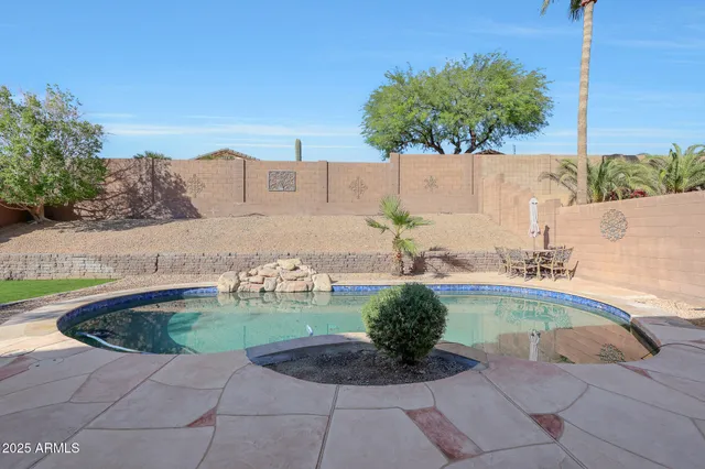 a swimming pool with outdoor seating and plants