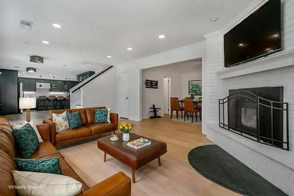 a living room with furniture a flat screen tv and a fireplace