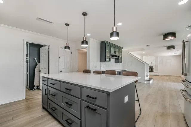a kitchen with a sink a stove and a wooden floor