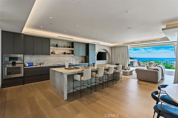 a living room with stainless steel appliances kitchen island granite countertop furniture and a fireplace