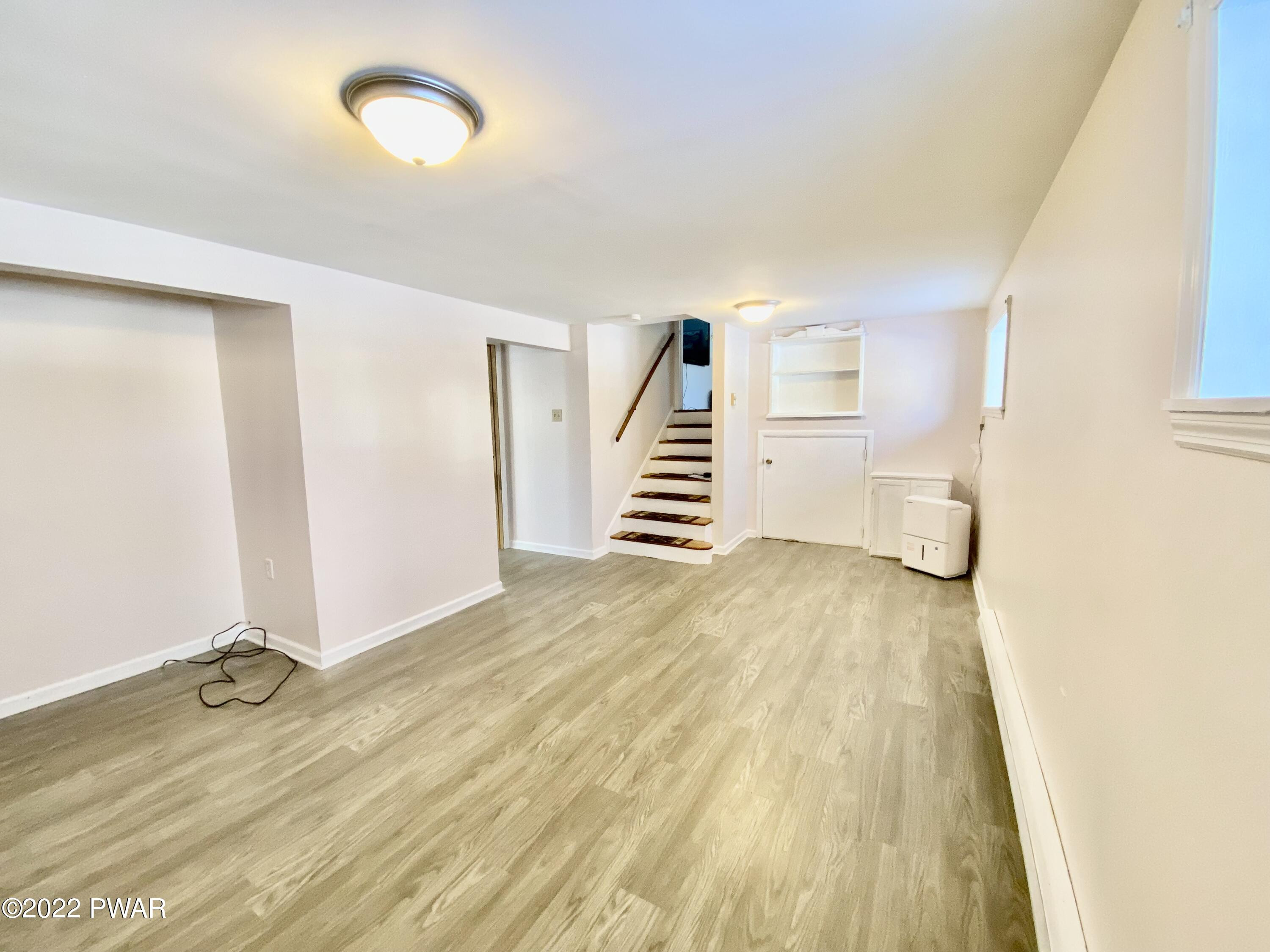 126 Roundhill Road Dingmans Ferry, PA 18328 - Photo 24 of 30 a view of a room with wooden floor and stairs