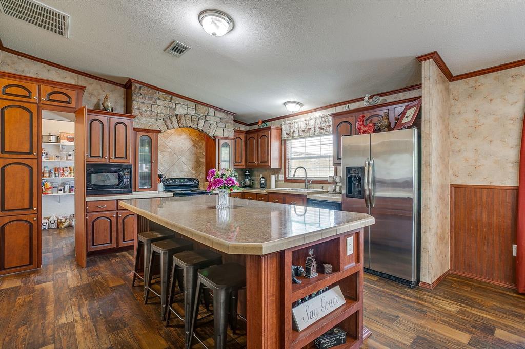 321 Young Road Millsap, TX 76066 - Photo 12 of 28 a kitchen with stainless steel appliances granite countertop a sink and a refrigerator