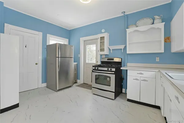 a kitchen with granite countertop white cabinets and white appliances