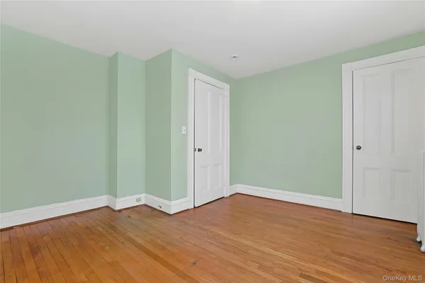 an empty room with closet and windows