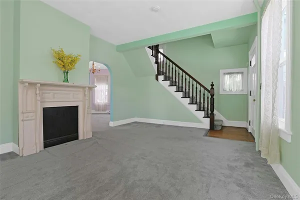 a view of an empty room with stairs and a fireplace