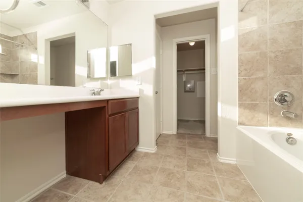 a bathroom with a tub sink and mirror