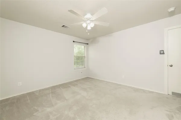 an empty room with a ceiling fan and a fan