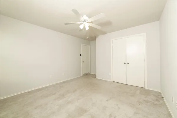 an empty room with a fan and a fan