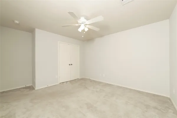 an empty room with a ceiling fan and a window
