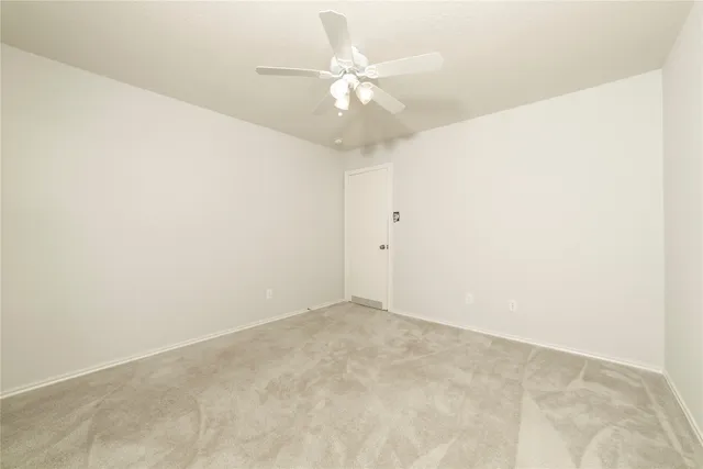 an empty room with fan and a ceiling fan
