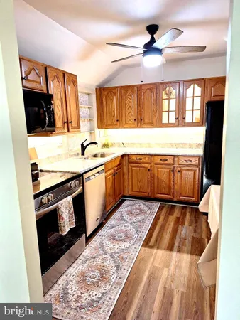 a kitchen with granite countertop stainless steel appliances stove sink and cabinets