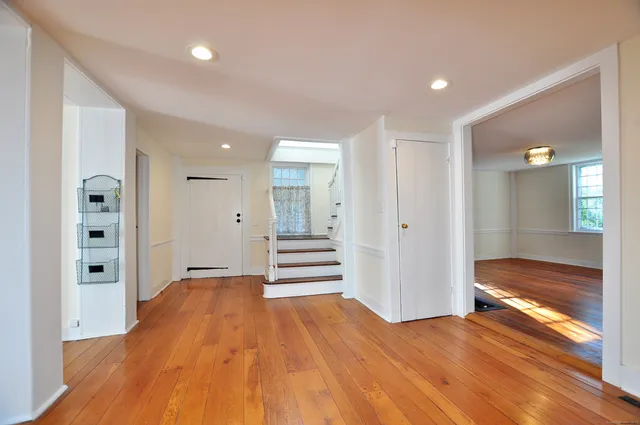 a view of a hallway with wooden floor and closet
