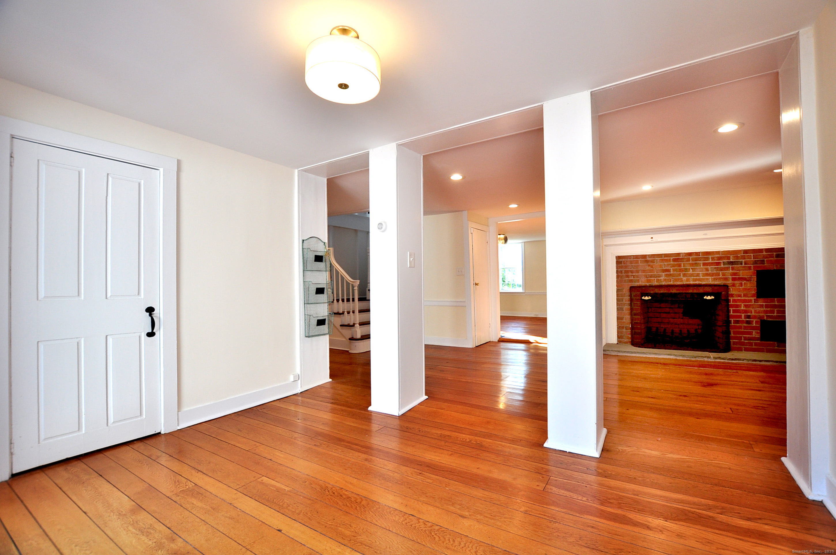 11 West Chestnut Hill Road Litchfield, CT 06759 - Photo 13 of 39 a view of an empty room with wooden floor and a fireplace