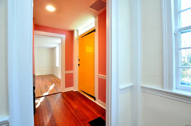 a view of a room with wooden floor and a bathroom