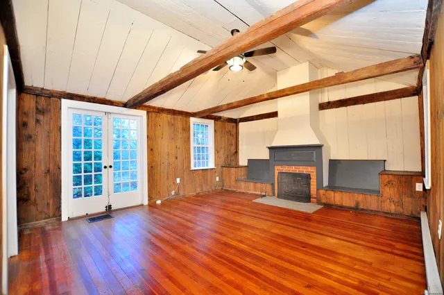 a view of empty room with wooden floor and fireplace