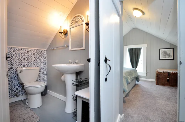 a bathroom with a toilet sink and mirror