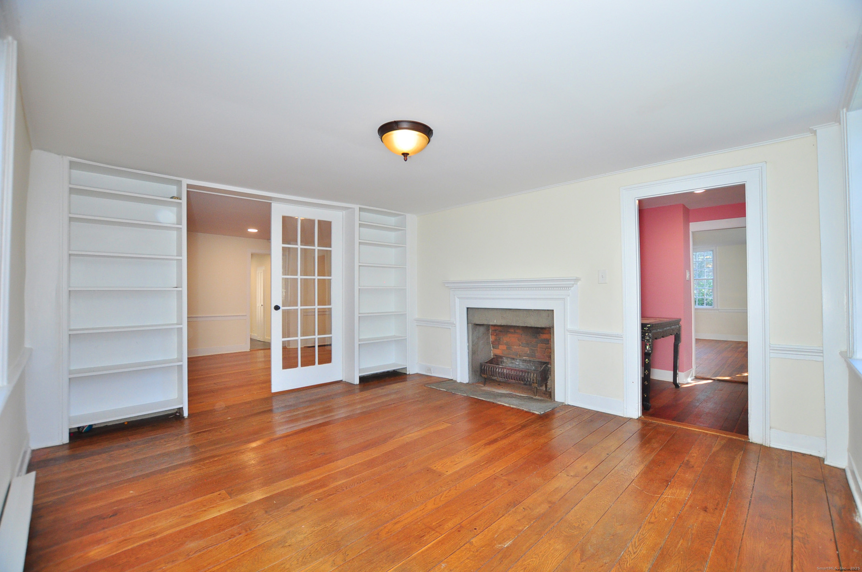 11 West Chestnut Hill Road Litchfield, CT 06759 - Photo 5 of 39 wooden floor fireplace and windows in an empty room
