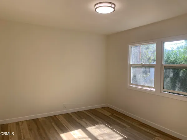 an empty room with wooden floor and a window