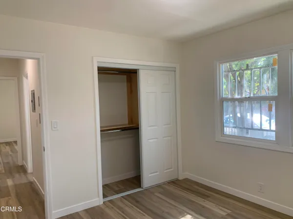 a view of empty room with wooden floor