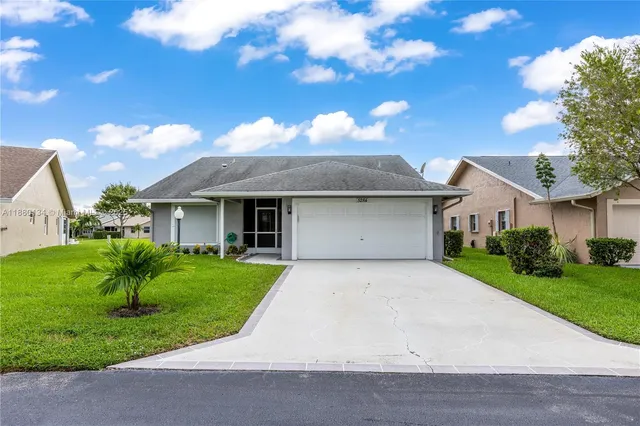 a front view of a house with a yard and trees