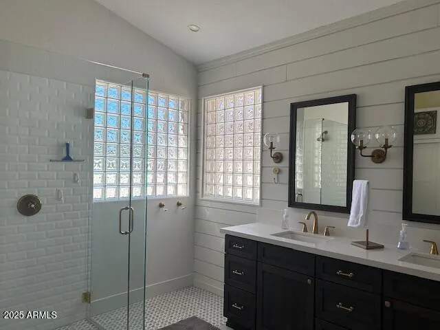 a bathroom with a double vanity sink mirror and shower