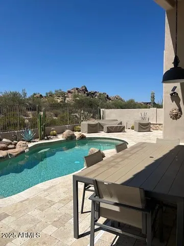 a view of a patio with table and chairs near a yard
