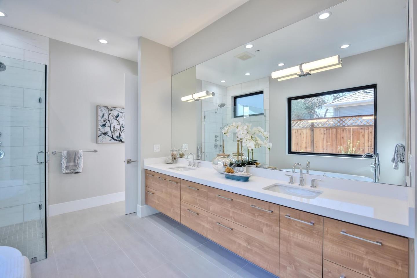 978 Covington Road Los Altos, CA 94024 - Photo 24 of 39 a bathroom with double vanity sinks double vanity tub and a mirror