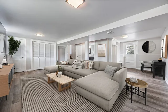 a living room with furniture and a wooden floor