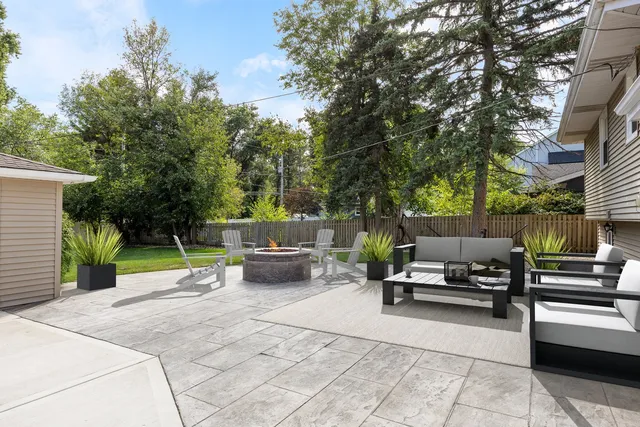 a view of a patio with dining table and chairs with a fire pit