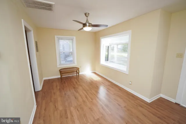 a view of a livingroom with wooden floor and a ceiling fan