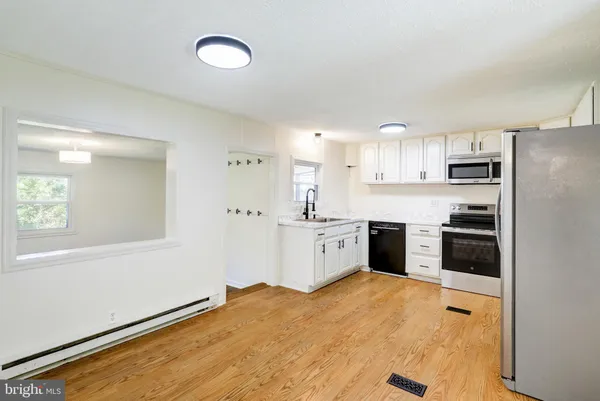 a kitchen with stainless steel appliances a refrigerator sink and cabinets