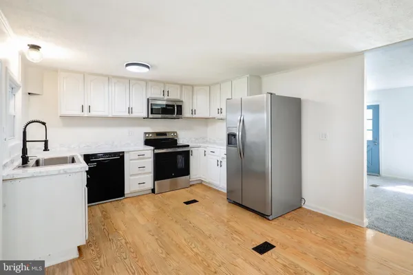 a kitchen with stainless steel appliances granite countertop a refrigerator sink and stove