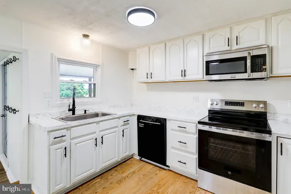 a kitchen with white cabinets stainless steel appliances and sink