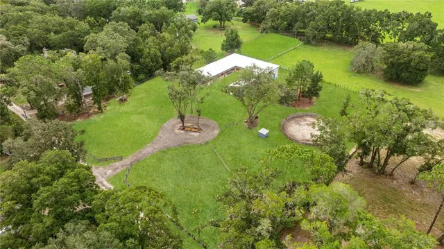 an aerial view of a house with a yard and lake view
