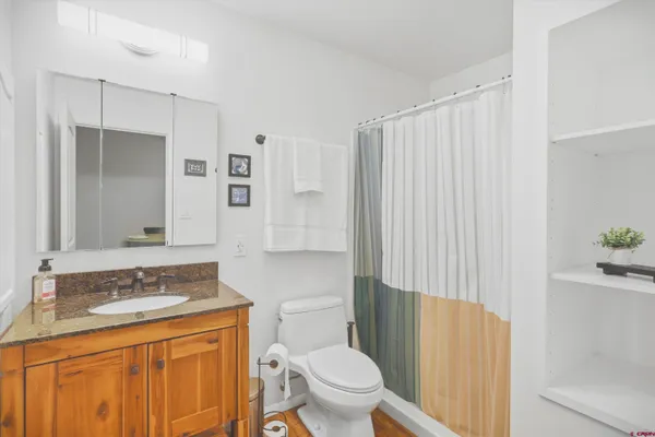 a bathroom with a granite countertop sink toilet and shower