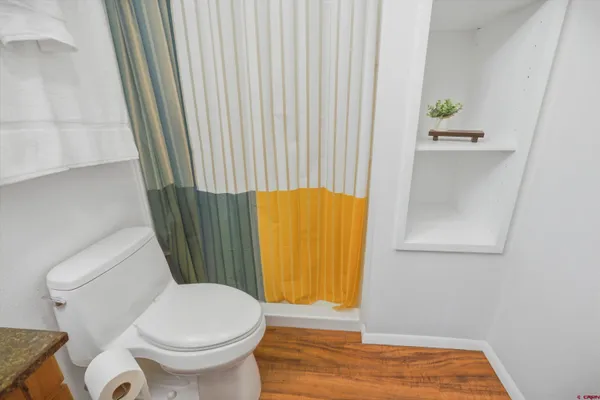 a bathroom with a toilet and a shower curtain